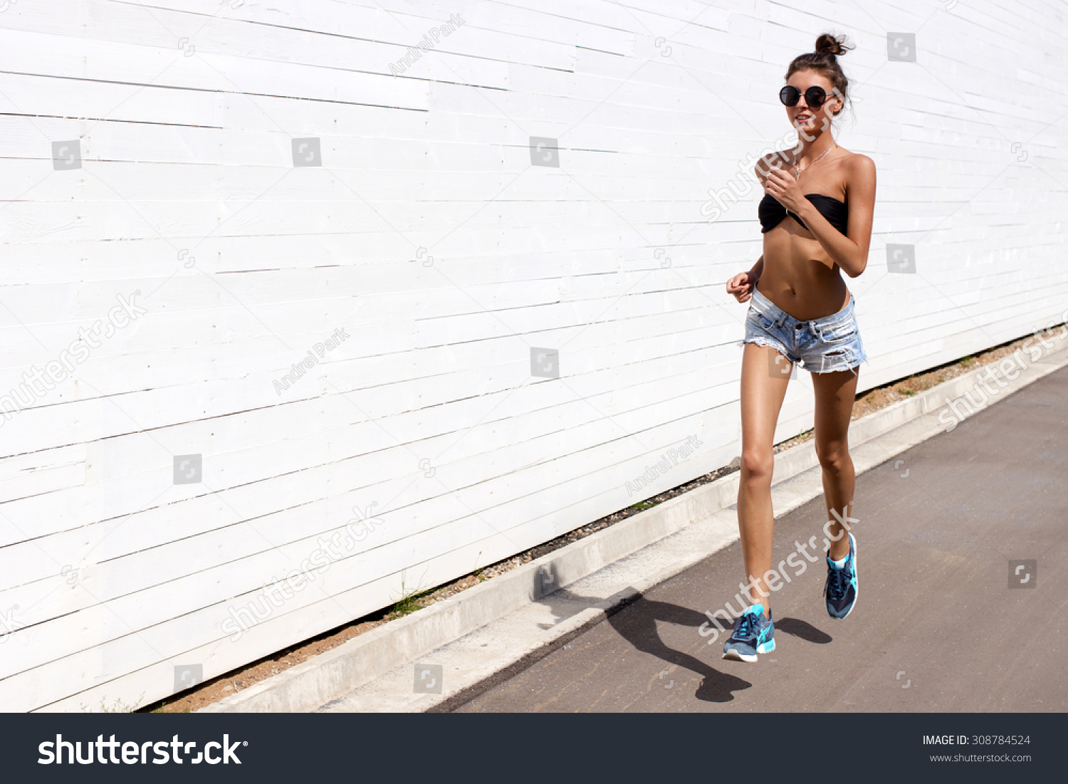 stock-photo-young-european-teenage-brunette-sports-model-running-outdoors-along-white-wooden-wall-jumping-308784524.jpg