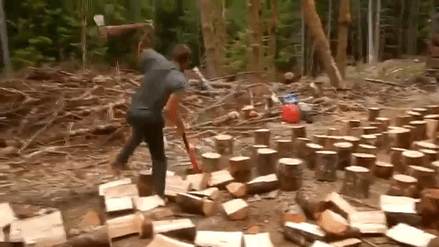 an-ambitious-man-splits-logs-very-quickly-with-two-axes.gif
