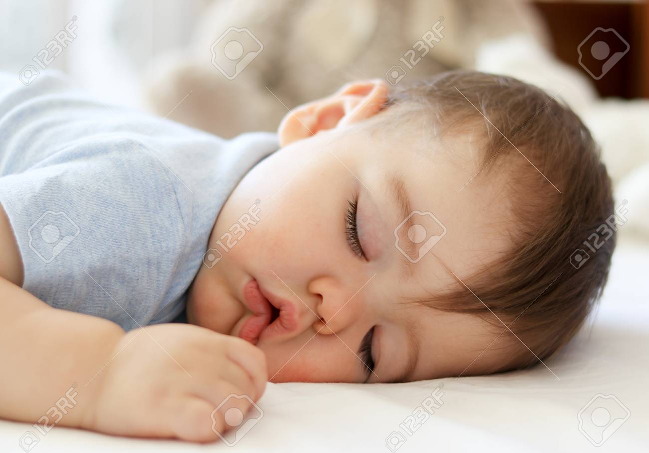 96112935-cute-little-baby-sleeping-on-stomach-with-funny-open-mouth-daytime-sleeping-close-up-.jpg